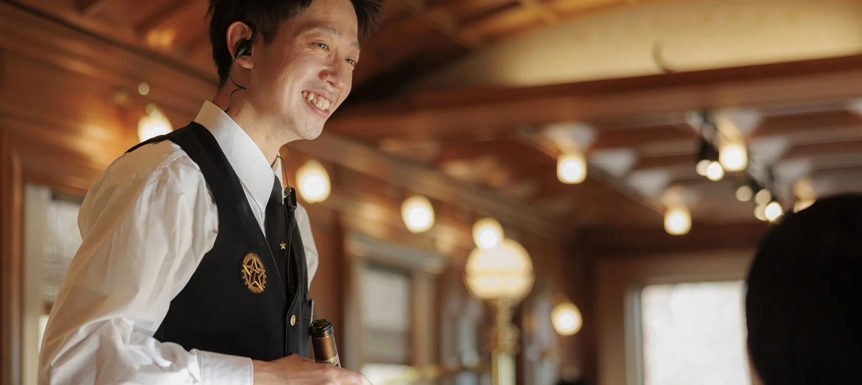 Personnel du Seven Stars in Kyushu souriant en uniforme dans la voiture &mdash; service omotenashi &agrave; bord du train de luxe JR Kyushu