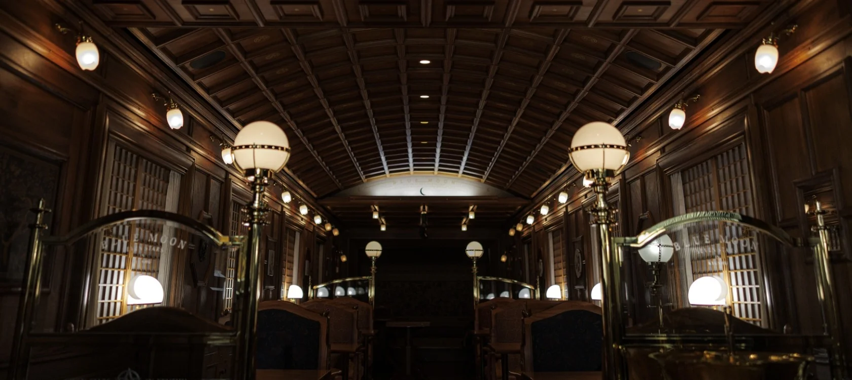 Salon Blue Moon du Seven Stars in Kyushu &mdash; int&eacute;rieur de nuit avec lustres dor&eacute;s et boiseries artisanales du train de luxe japonais