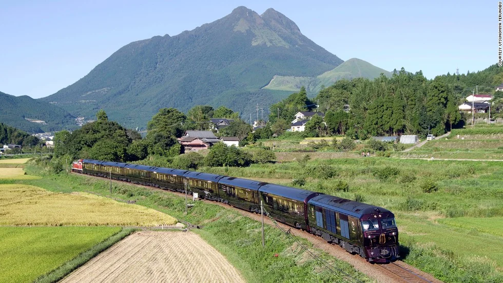 Seven Stars in Kyushu traversant la campagne de Kyushu avec le mont Yufu en arri&egrave;re-plan &mdash; train de luxe JR Kyushu