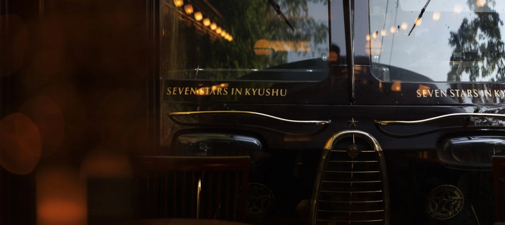 Seven Stars in Kyushu &mdash; fa&ccedil;ade bordeaux royal avec logo dor&eacute; et lettres or des sept pr&eacute;fectures de Kyushu