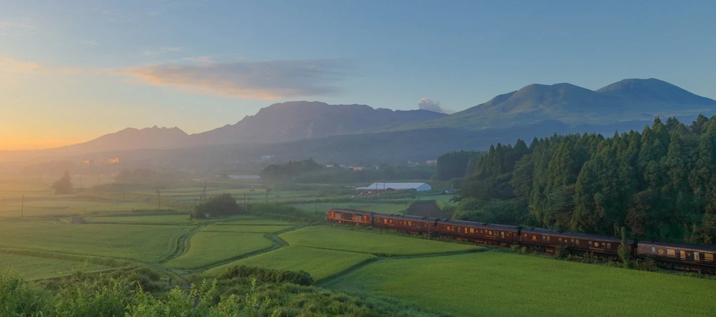 Seven Stars in Kyushu traversant la campagne au lever du soleil &mdash; paysage de rizi&egrave;res et montagnes volcaniques de Kyushu