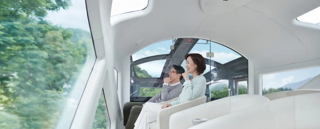 View Terrace du Train Suite Shiki-Shima &mdash; couple dans le salon dome panoramique avec toit vitr&eacute; face aux for&ecirc;ts japonaises