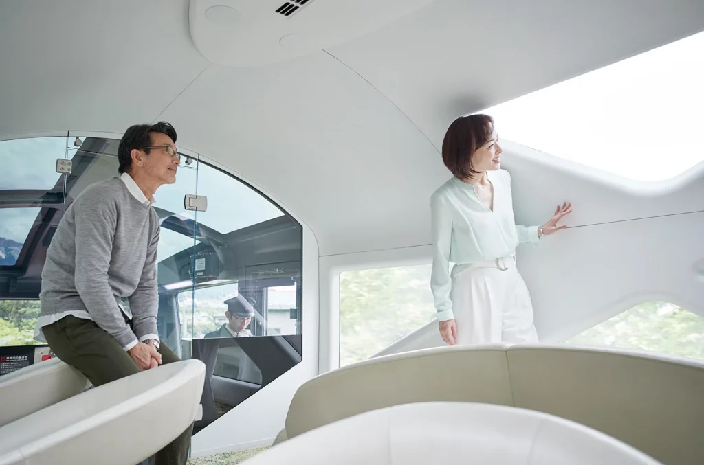 View Terrace avant du Train Suite Shiki-Shima &mdash; voyageurs face &agrave; la cabine du conducteur, panorama sur la voie et les montagnes japonaises