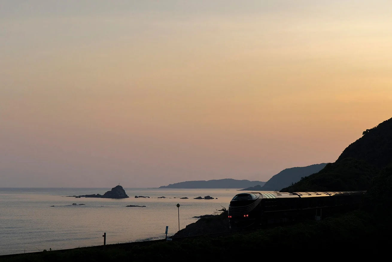 Twilight Express Mizukaze au coucher du soleil face &agrave; la mer du Japon &mdash; silhouette du train de luxe JR West dans la lumi&egrave;re dor&eacute;e