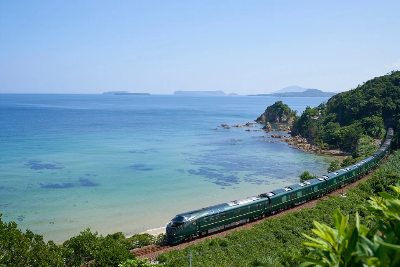 Twilight Express Mizukaze longeant la mer du Japon turquoise &mdash; vue a&eacute;rienne du train de luxe JR West sur la c&ocirc;te San'in
