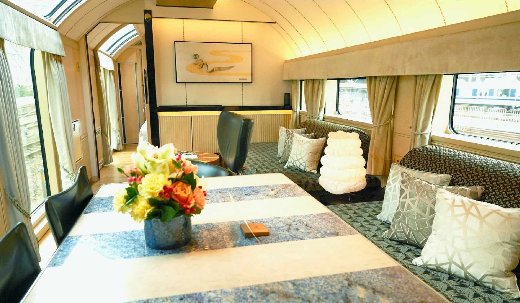 Suite salon du Twilight Express Mizukaze avec coin repas luxueux et banquettes design